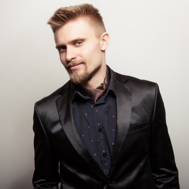 Siyah kostümlü zarif genç yakışıklı adam. Studio moda portre.