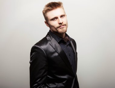 Siyah kostümlü zarif genç yakışıklı adam. Studio moda portre.