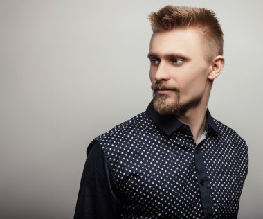 Tişörtlü zarif genç yakışıklı adam. Studio moda portre.