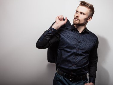 Tişörtlü zarif genç yakışıklı adam. Studio moda portre.