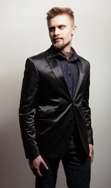 Elegant ung vacker man i svart kostym. Studio mode porträtt. — Stockfoto
