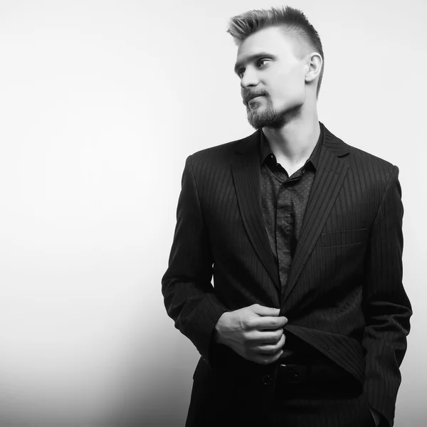 Elegant ung vacker man i svart kostym. Svart-vit studio mode porträtt. — Stockfoto