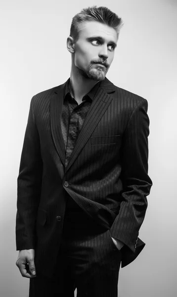 Elegante joven guapo con traje negro. Retrato de moda estudio blanco y negro . — Foto de Stock
