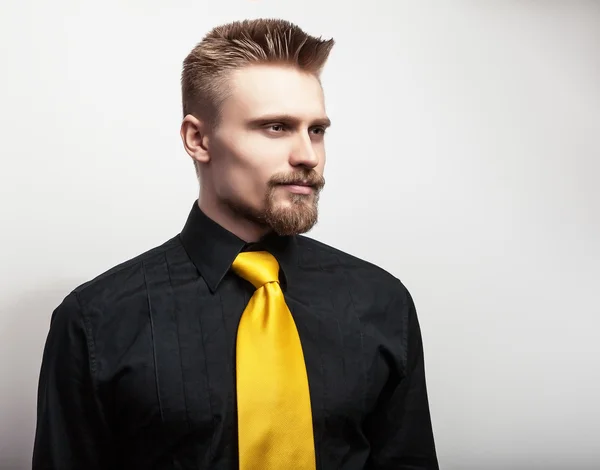 Elegante giovane bell'uomo in camicia nera e cravatta gialla. Studio ritratto di moda . — Foto Stock