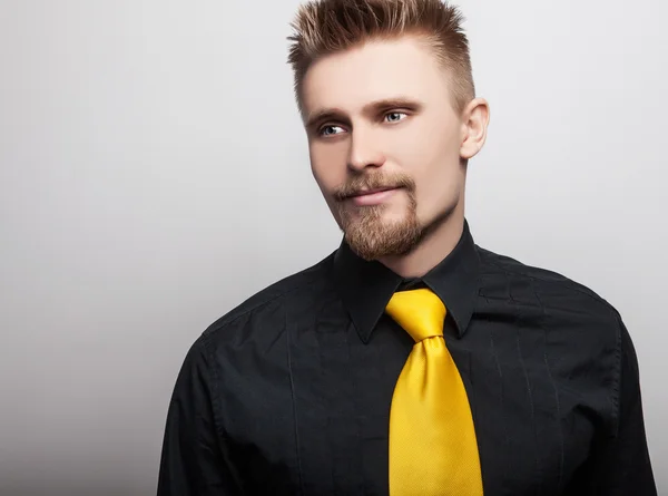 Elégant jeune homme beau en chemise noire et cravate jaune. Studio portrait de mode . — Photo