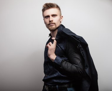 Tişörtlü zarif genç yakışıklı adam. Studio moda portre.