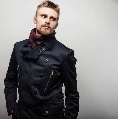 Siyah montlu zarif genç yakışıklı adam. Studio moda portre.