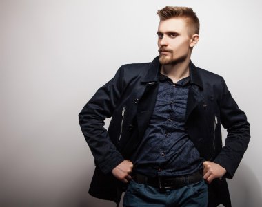 Siyah montlu zarif genç yakışıklı adam. Studio moda portre.