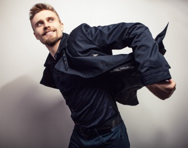 Siyah montlu zarif genç yakışıklı adam. Studio moda portre.