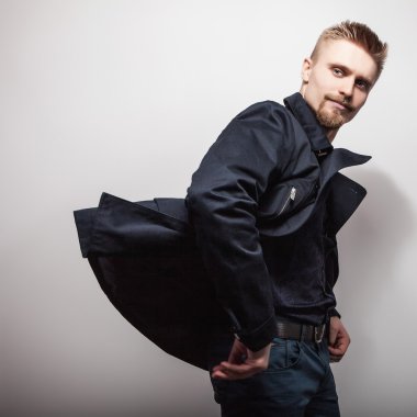 Siyah montlu zarif genç yakışıklı adam. Studio moda portre.