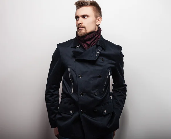 Elegante giovane bell'uomo in cappotto nero. Studio ritratto di moda . — Foto Stock