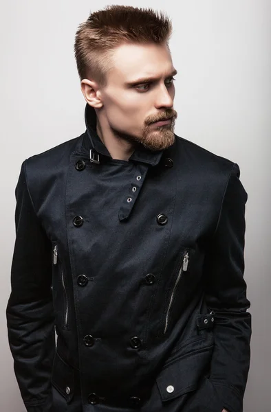 Elegancki młody przystojny mężczyzna w czarnym płaszczu. Studio moda piękny portret. — Zdjęcie stockowe