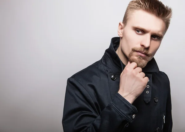 Elegante jovem e bonito homem de casaco preto. Estúdio retrato de moda . — Fotografia de Stock