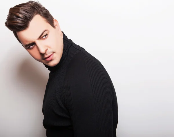 Studio portrait of young handsome man in black knitted sweater. Close-up photo. — Stock Photo, Image