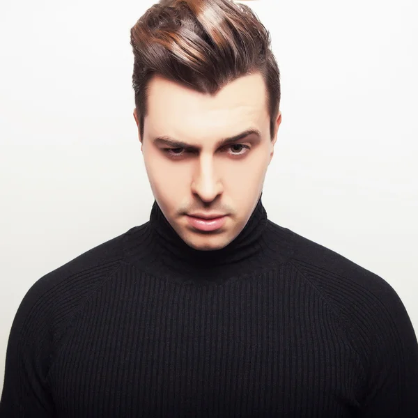 Studio portrait of young handsome man in black knitted sweater. Close-up photo. — Stock Photo, Image