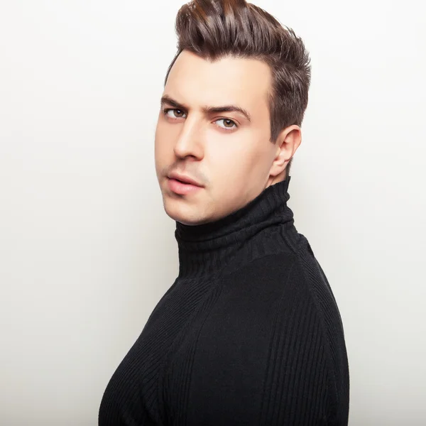 Studio portrait of young handsome man in black knitted sweater. Close-up photo. — Stock Photo, Image