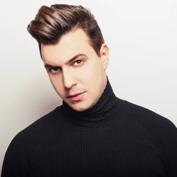 Studio portrait of young handsome man in black knitted sweater. Close-up photo. — Stock Photo, Image