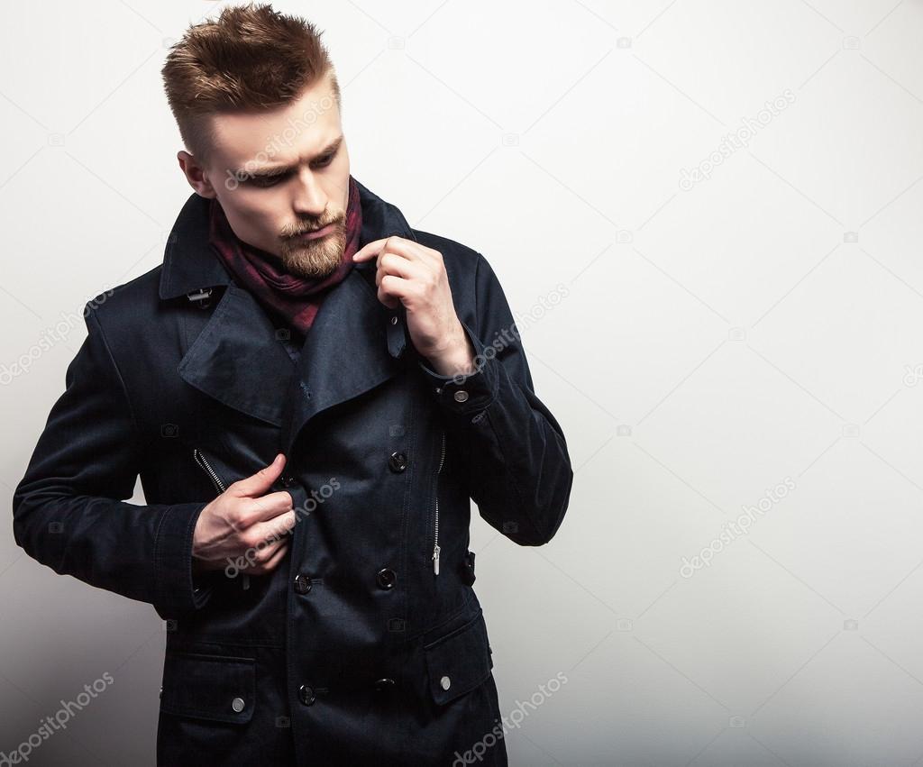 Elegant young handsome man in black coat. Studio fashion portrait.