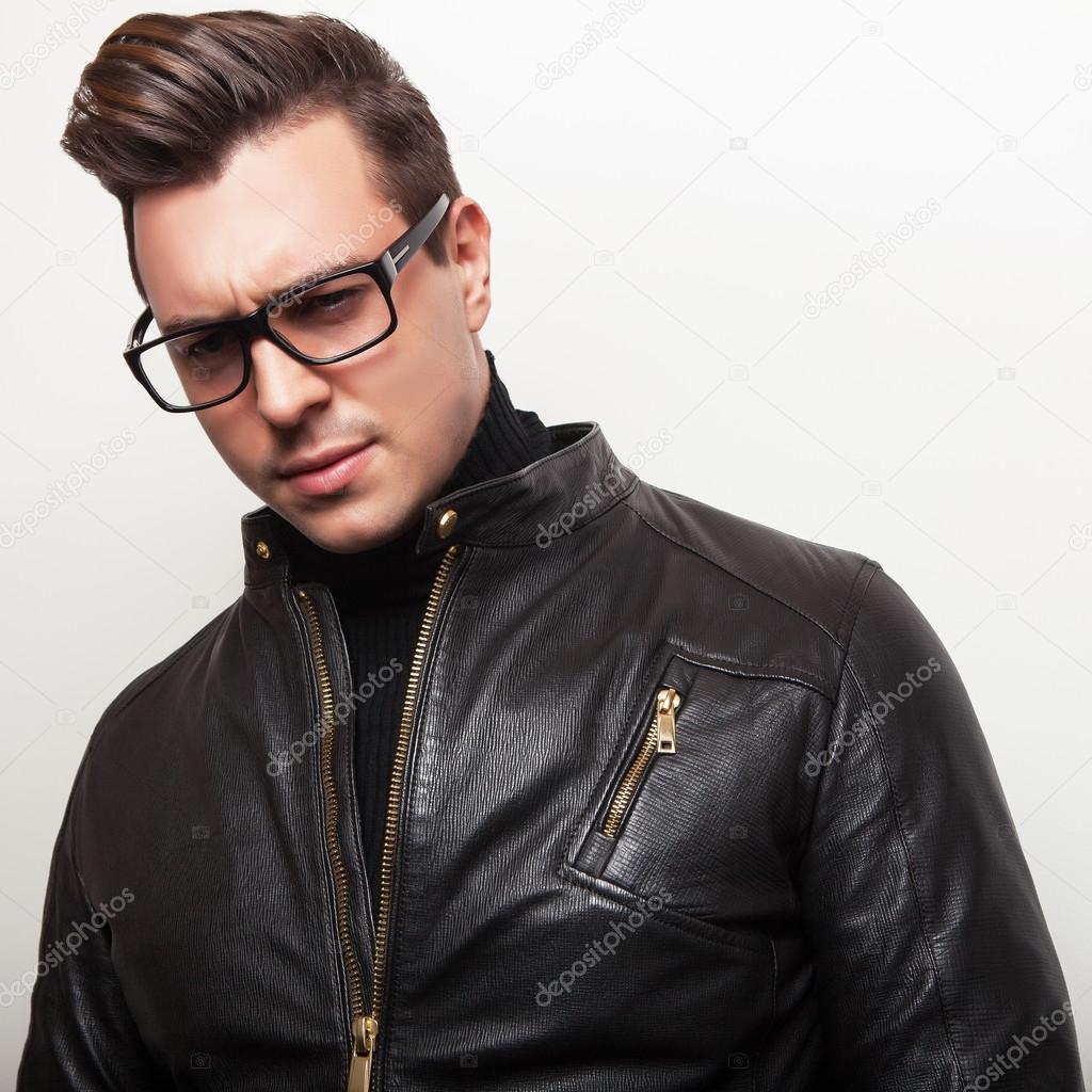 Elegant young handsome man in black leather jacket and stylish glasses.