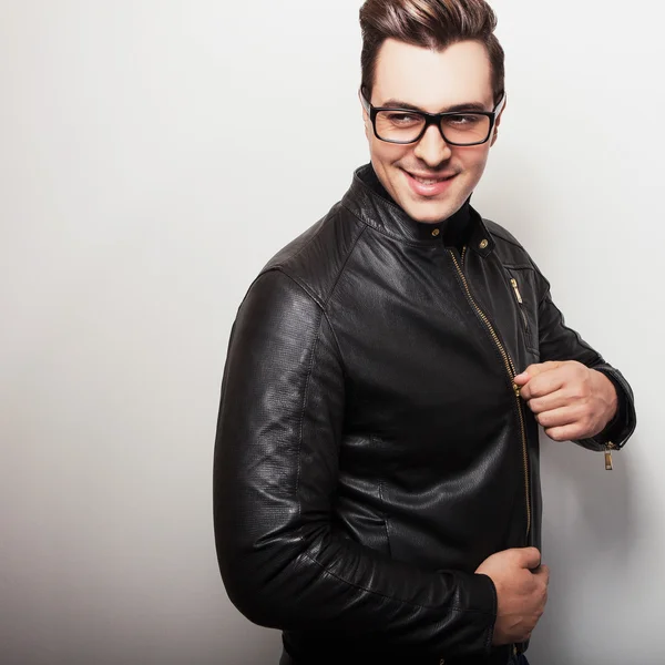 Elegant young handsome man in black leather jacket and stylish glasses. — Stock Photo, Image