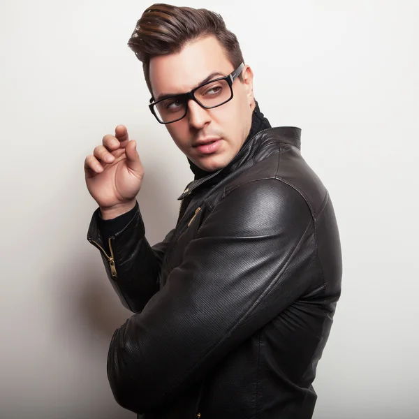 Elegant young handsome man in black leather jacket and stylish glasses. — Stock Photo, Image