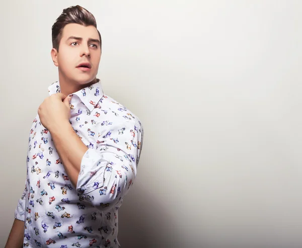 Elegante jonge knappe man in heldere kleurrijke shirt. Studio mode portret. — Stockfoto