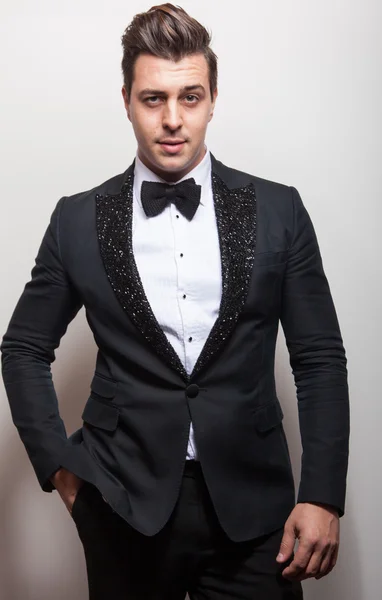 Elegante jonge knappe man in zwarte luxe kostuum. Studio mode portret. — Stockfoto