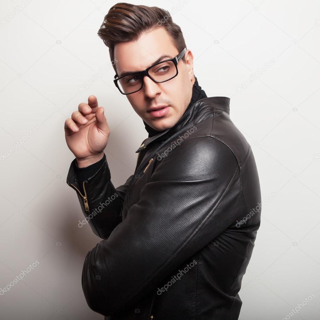 Elegant young handsome man in black leather jacket and stylish glasses.