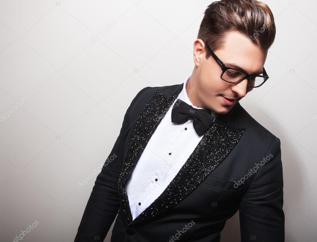 Elegant young handsome man in black luxury costume. Studio fashion portrait.