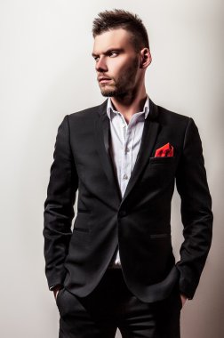 Zarif genç yakışıklı ciddi adam siyah kostüm. Studio moda portre.
