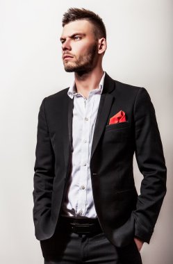Zarif genç yakışıklı ciddi adam siyah kostüm. Studio moda portre.