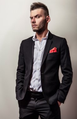 Zarif genç yakışıklı ciddi adam siyah kostüm. Studio moda portre.