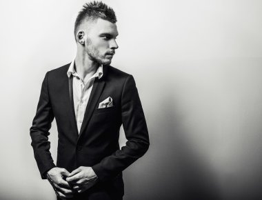 Zarif genç yakışıklı ciddi adam klasik kostüm. Siyah-beyaz studio moda portre.