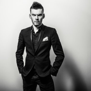 Zarif genç yakışıklı ciddi adam klasik kostüm. Siyah-beyaz studio moda portre.