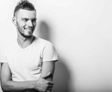 Stüdyo portre rahat beyaz t-shirt genç yakışıklı adam. Siyah-beyaz yakın çekim fotoğraf.