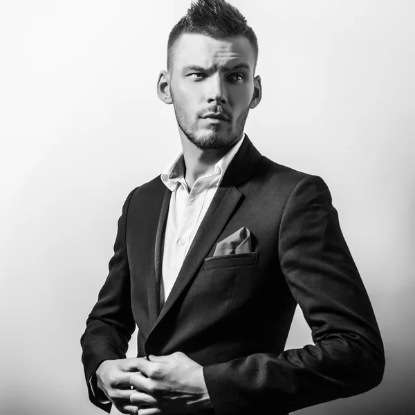 Elégant jeune homme beau et sérieux en costume classique. Portrait de mode studio noir-blanc . — Photo