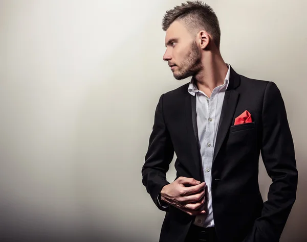 Elegante joven guapo hombre serio en traje negro. Estudio retrato de moda . —  Fotos de Stock