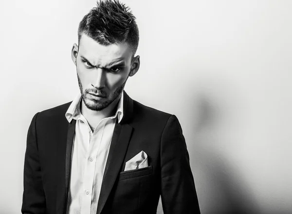 Elegante joven guapo hombre serio en traje clásico. Retrato de moda estudio blanco y negro . —  Fotos de Stock