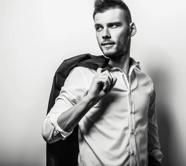 Elegante joven guapo hombre serio en camisa blanca. Retrato de moda estudio blanco y negro . — Foto de Stock