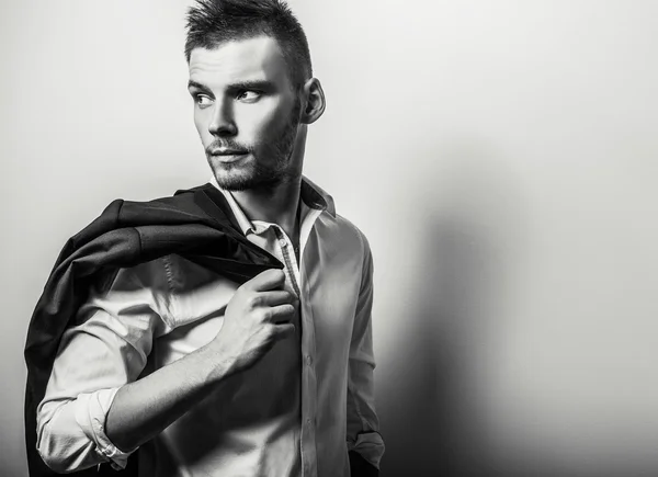 Elegante joven guapo hombre serio en camisa blanca. Retrato de moda estudio blanco y negro . — Foto de Stock