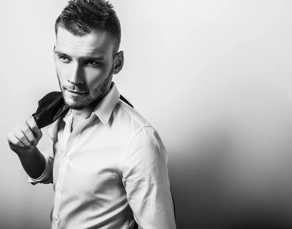 Elégant jeune homme beau et sérieux en chemise blanche. Portrait de mode studio noir-blanc . — Photo