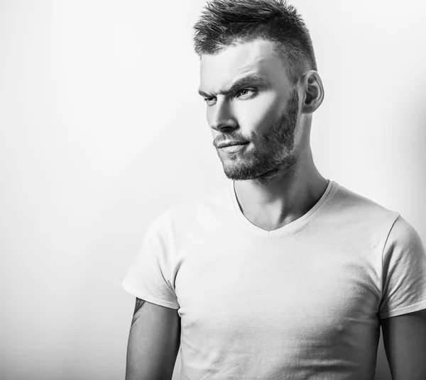 Studio portrait of young handsome man in casual white t-shirt. Black-white close-up photo. — Stock Photo, Image