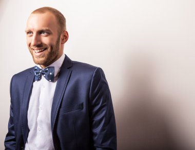 Zarif genç yakışıklı adam koyu mavi kostüm ve papyon. Studio moda portre.