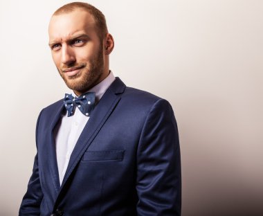 Zarif genç yakışıklı adam koyu mavi kostüm ve papyon. Studio moda portre.