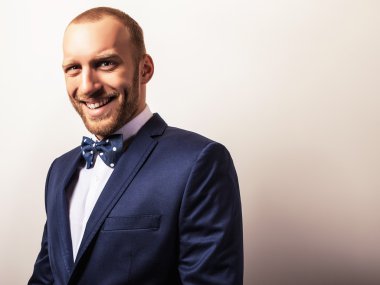 Zarif genç yakışıklı adam koyu mavi kostüm ve papyon. Studio moda portre.
