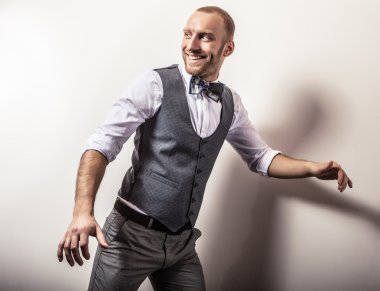 Gri kostümlü zarif genç yakışıklı adam. Studio moda portre.