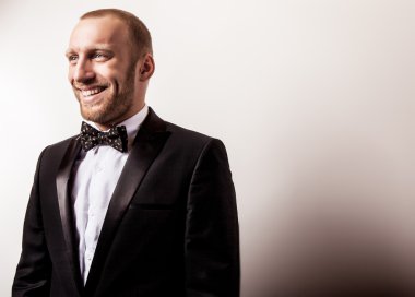 Zarif genç gülümseyen yakışıklı siyah kostüm. Studio moda portre.