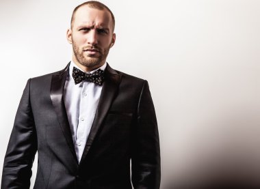 Zarif genç gülümseyen yakışıklı siyah kostüm. Studio moda portre.