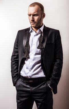 Zarif genç gülümseyen yakışıklı siyah kostüm. Studio moda portre.