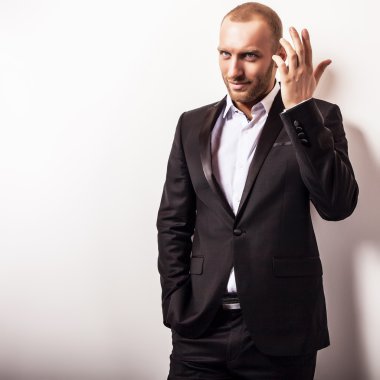 Zarif genç gülümseyen yakışıklı siyah kostüm. Studio moda portre.